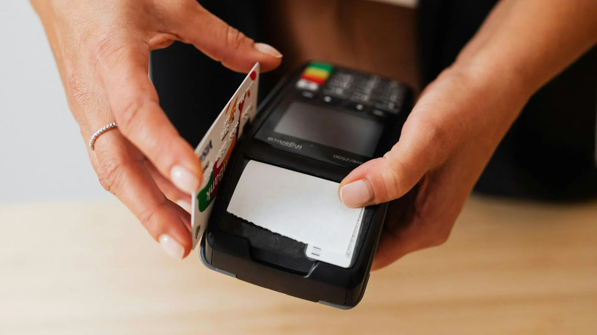 Main insérant une carte bancaire dans un TPE, illustrant la simplicité d'affectation comptable par praticien en un clic