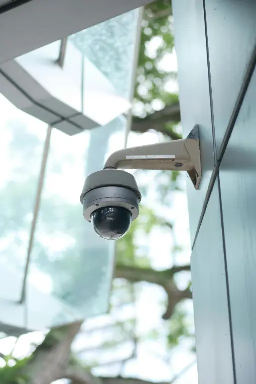 Caméra de surveillance installée en hauteur, symbolisant la vigilance et la détection des comportements suspects autour d'un terminal de paiement