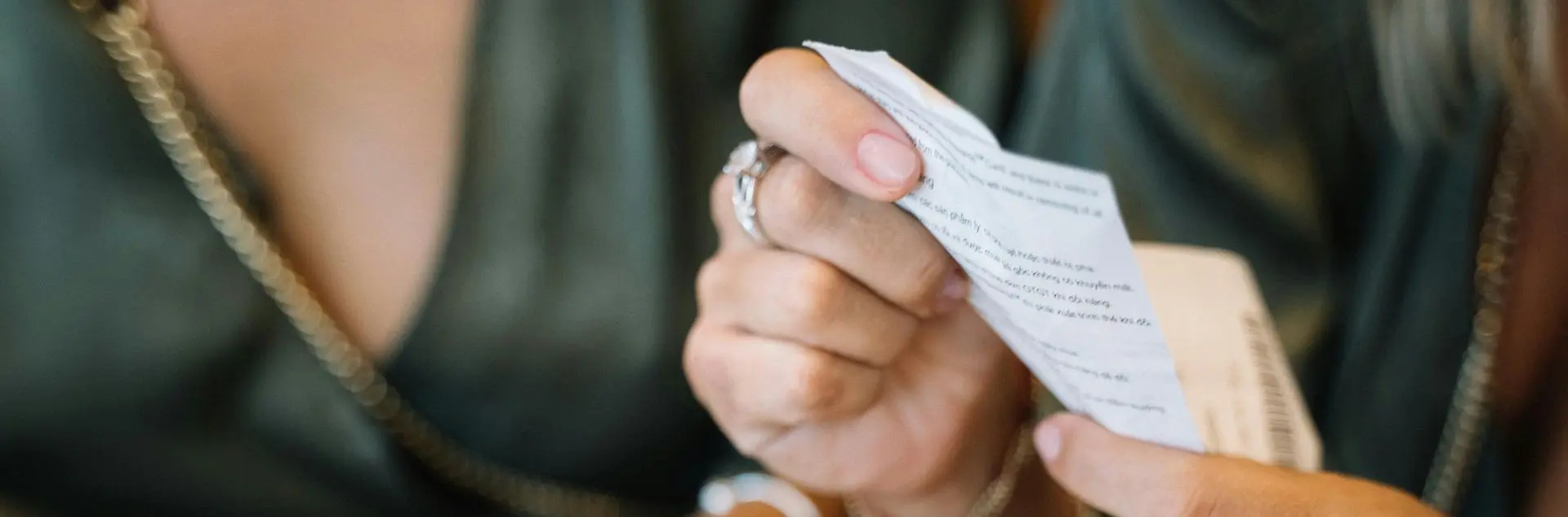 Routine quotidienne tickets TPE : récupérer, vérifier et numériser chaque soir Commerçante vérifiant et numérisant ses tickets de caisse en fin de journée pour archivage comptable