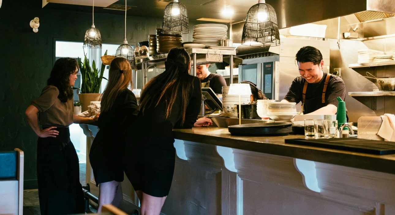 Équipe de restauration au comptoir, heureuse de profiter de la gestion simplifiée des pourboires sur leur TPE grâce à Payludd.