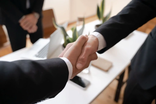 Poignée de main professionnelle entre deux partenaires d'affaires au-dessus d'un bureau.
